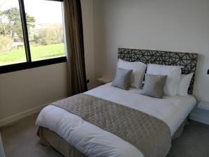 a bedroom with a large white bed with a window at Les Gîtes du Cap Cod in Varengeville-sur-Mer