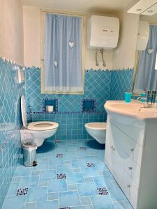 bagno piastrellato blu con servizi igienici e lavandino di Casa Vacanze Miranda a Torre Dei Corsari