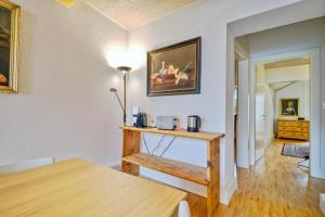 a living room with a table and a painting on the wall at Duplex de charme au cœur de la vieille ville de Sion in Sion +10 photos