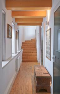 um corredor com escadas e um banco de madeira em Duplex de charme au cœur de la vieille ville de Sion em Sião