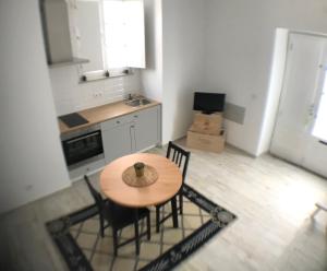 a kitchen with a wooden table and chairs in a room at Mouraria House - Casa de Charme - Centro Histórico in Évora