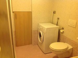 a bathroom with a toilet and a washing machine at Appartamenti Piazzi in Tesero +24 photos