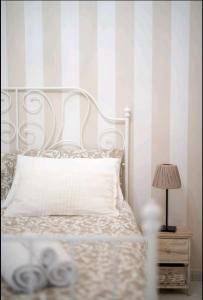 a bedroom with a bed and a striped wall at Borgo Santa Lucia Apartment in Naples