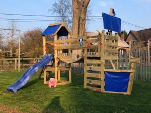 a wooden playground with a slide and a playset at Villa Athena in Assesse