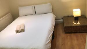 倫敦的住宿－海德公園客房公寓，一间卧室配有一张床,上面有两条毛巾