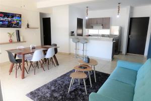 a living room with a blue couch and a table and chairs at Ideal tu casa fuera de casa in Cancún