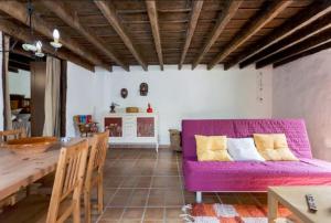 sala de estar con sofá púrpura y mesa en Casa Canaria Tradicional Rosalía, en Los Silos