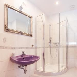 a bathroom with a purple sink and a shower at Villa Greifenberg in Jelenia Góra-Jagniątków