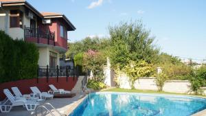 a swimming pool in front of a house with chairs at Summer Breeze Villa in Balchik