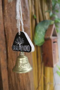 een bel met een bord dat zegt Aziatisch Menota bij Casa Almendro in Tulum