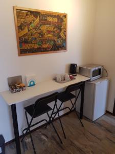 una scrivania con 2 sedie e un forno a microonde di Foresteria Giulia a Bergamo