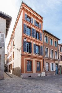 a large brick building with windows on a street at Appartement Le Paon in Toulouse