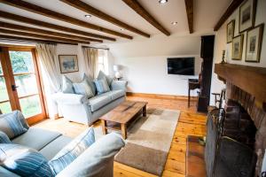 sala de estar con sofá y chimenea en Beautiful 3 Bedroom Cottage - Picturesque Retreat, en Lichfield