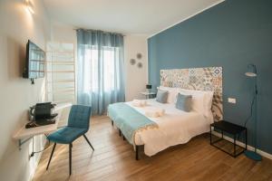 een slaapkamer met een bed, een bureau en een stoel bij Casa Stazione in Verona