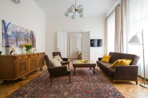 een woonkamer met een bank, stoelen en een tafel bij Belle Epoque II, luxury suite 50m to Main Square in Krakau