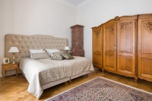 een slaapkamer met een groot bed en een grote houten kast bij Belle Epoque II, luxury suite 50m to Main Square in Krakau