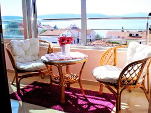 Habitación con mesa, 2 sillas y ventana en Apartments Linda, en Trogir