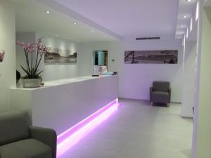 a waiting room with two chairs and a counter with purple lights at Apartamentos Cristina in Cala Millor