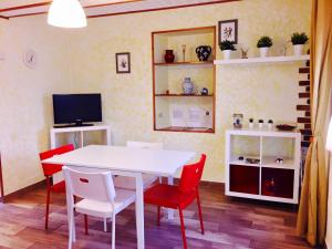 una sala da pranzo con tavolo bianco e sedie rosse di Camere e Casa Vacanze a Misano Adriatico