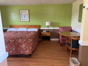 a hotel room with a bed and a table at Royal Inn Motel in Waynesboro