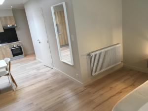 ein leeres Wohnzimmer mit Holzböden und einer Küche in der Unterkunft Studio 't Ponton in Nieuwpoort