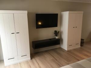 een woonkamer met twee witte kasten en een tv bij Studio 't Ponton in Nieuwpoort