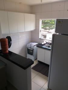 a small kitchen with a refrigerator and a window at Apartamento Cidade Verde 7 MT in Maringá