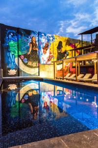 una piscina con una pintura en el lateral de un edificio en Cabane Container Hotel - ADULTS ONLY, en Puerto Escondido