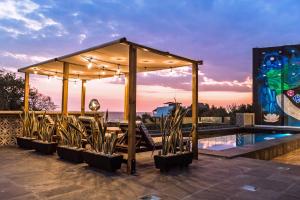 a gazebo with chairs and a swimming pool at Cabane Container Hotel - ADULTS ONLY in Puerto Escondido