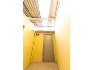 pasillo con puerta amarilla y techo en KIT 5 - Estúdio com churrasqueira piscina ar wifI vaga cozinha, en Itapema
