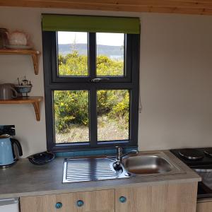 a kitchen counter with a sink and a window at Dingle Way Glamping in Anascaul