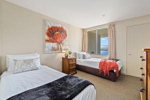 a bedroom with two beds and a window at Oriwa View in Queenstown