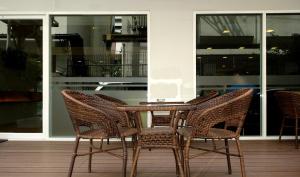 a rattan table and chairs sitting on a patio at Nantra Silom in Bangkok