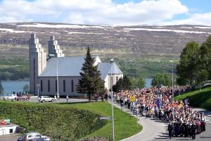 a large group of people walking down a road in front of a church at Day Dream Kaupvangsstræti 19 in Akureyri
