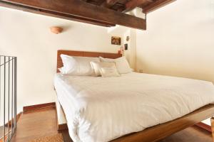 フィレンツェにあるLambertesca il Cuore di Firenzeのベッドルーム1室(大型ベッド1台、白いシーツ、枕付)