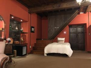 a bedroom with red walls and a bed with white sheets at Pazo de Laia in Palas de Rei