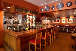 a bar with wooden counter tops and chairs in a restaurant at Hotel Chimayo de Santa Fe in Santa Fe