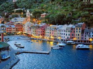 una città con barche in acqua di notte di Porta Soprana Old Town with FREE PRIVATE PARKING included! a Genova