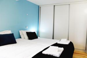 a bedroom with a large bed with white and black pillows at Quebra Luz in Coimbra