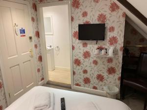 a bedroom with a mirror and a tv on the wall at The Ivy in Wragby