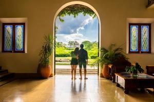 奇琴伊察玛亚兰简易别墅酒店的一对夫妇站在一扇敞开的门前