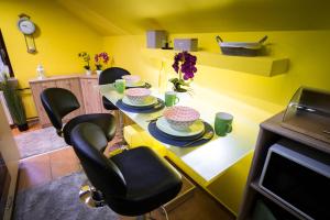a dining room with yellow walls and a table with chairs at Apartment Jacobs in Bled
