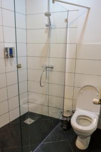 a bathroom with a toilet and a glass shower stall at 3 Studio in Tbilisi City +8 photos
