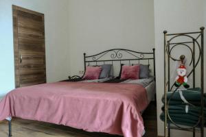 um quarto com uma cama com uma colcha rosa em 3 Studio em Tbilisi