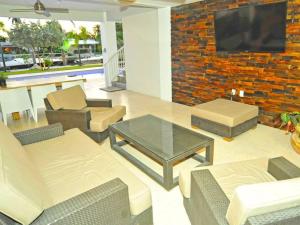 a living room with a brick wall with a tv at Villa Estelle in Miami