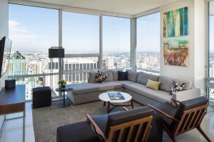 een woonkamer met een bank, stoelen en ramen bij Luxurious Highrise 2b 2b Apartment Heart Of Downtown LA in Los Angeles