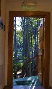 una puerta abierta con vistas a un bosque en Familia Piatti B&B - Suites en Ushuaia