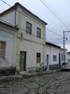 Un bâtiment blanc avec une voiture garée devant. dans l'établissement Casa por temporada, à Goiás