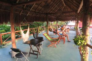 a group of people sitting in hammocks on a patio at Casa Almendro in Tulum