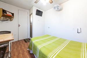 a bedroom with a bed with a green blanket at Hotel Econômico ao lado do Metrô in São Paulo